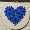 close-up-blue-heart-made-flowers-white-cloth