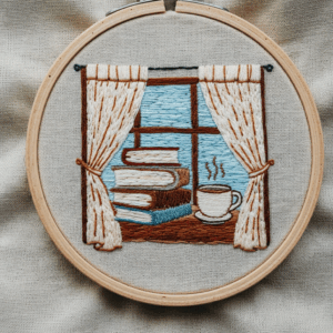 close-up-cross-stitched-picture-window-cup-coffee