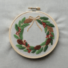 close-up-cross-stitched-wreath-pine-cones-berries