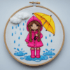 close-up-embroidery-girl-pink-raincoat-holding-umbrella