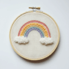 close-up-embroideryed-rainbow-clouds-white-surface