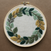 close-up-embroideryed-wreath-leaves-brown-surface