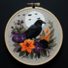 arafed-embroidery-black-bird-sitting-branch-flowers