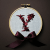 arafed-embroidery-letter-v-bow-brown-background
