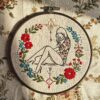 arafed-embroidery-woman-sitting-bed-flowers