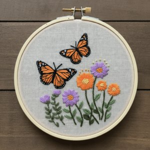 embroidery-butterfly-flowers-wooden-surface