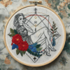 embroidery-woman-sitting-flowered-table-clock