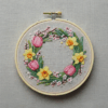 embroidery-wreath-flowers-leaves-white-surface