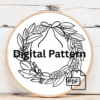 close-up-cross-stitched-wreath-pine-cones-berries